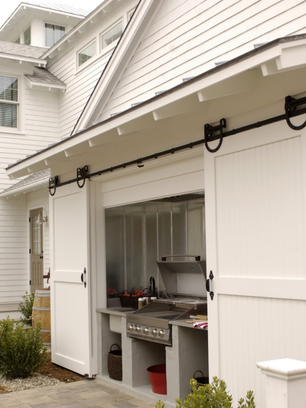 Sliding barn doors reveal an outdoor kitchen.
