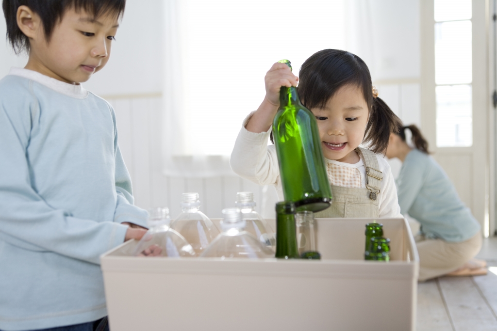 Brother and sister separating plastic bottles