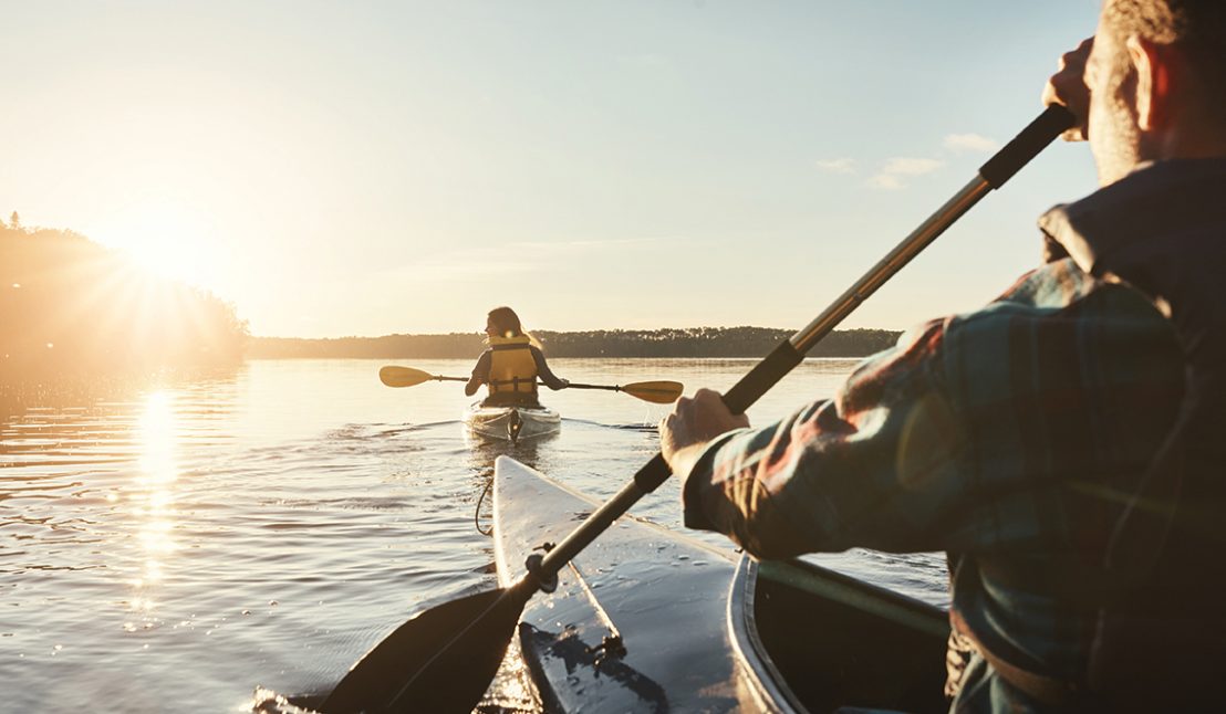 Kayak, lake and people rowing a boat on the water during summer for recreation or leisure at sunset. Nature, view and horizon with people canoeing for adventure, freedom or travel while on vacation Kayak, lake and people rowing a boat on the water during summer for recreation or leisure at sunset. Nature, view and horizon with people canoeing for adventure, freedom or travel while on vacation.